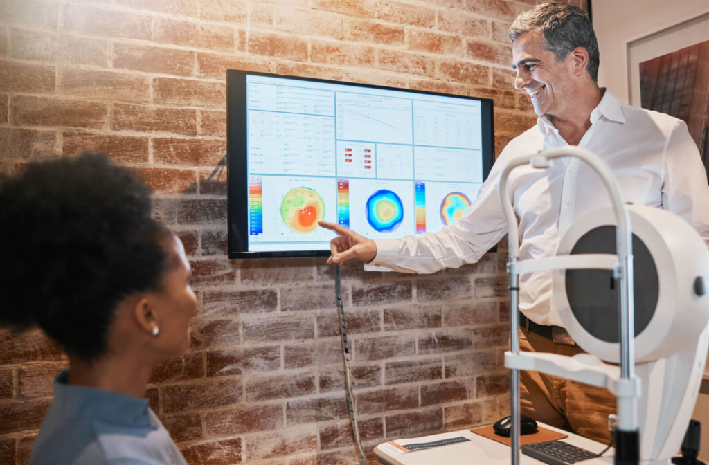 An optometrist showing the results of retinal imaging to his patient.