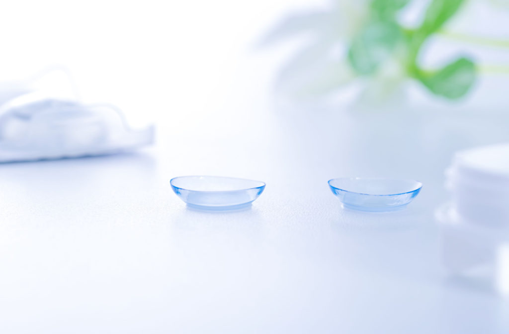 A pair of contact lenses on a white surface.
