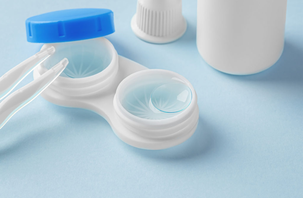 A pair of contact lenses submerged in case full of cleaning solution.