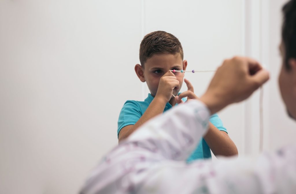 An eye doctor helps a child exercise their convergence using a Brock string.