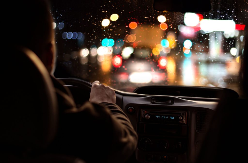 A driver focuses on blurry and haloed night driving conditions.