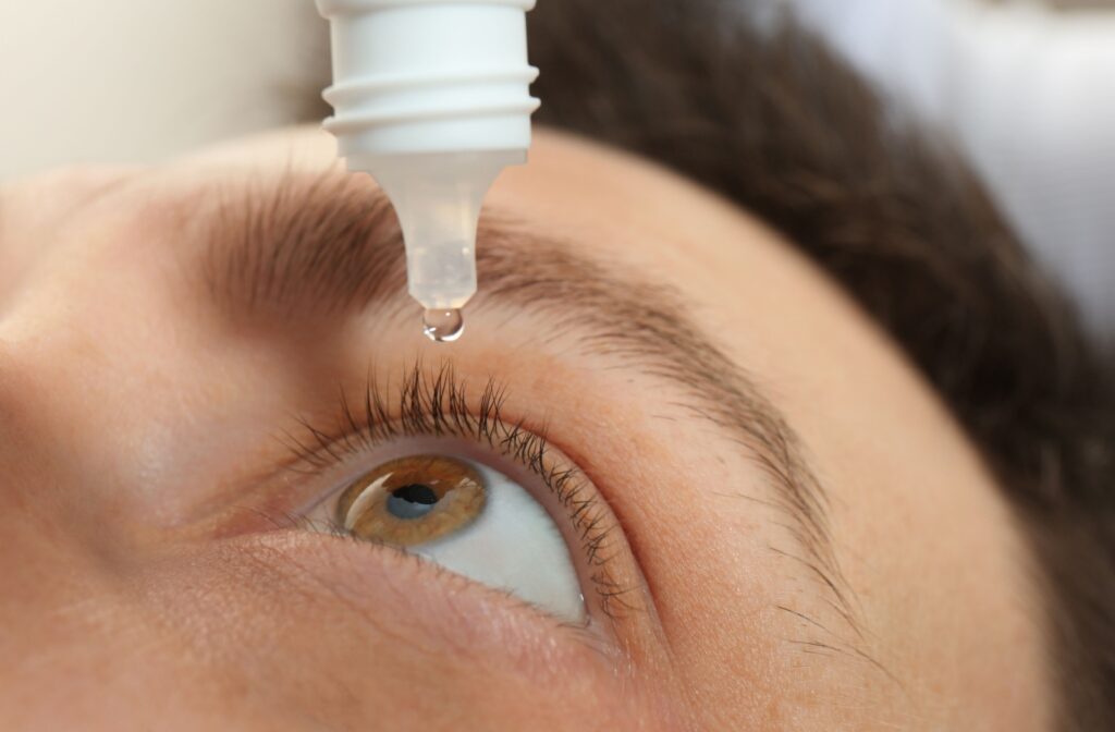 A person applying eye drops.