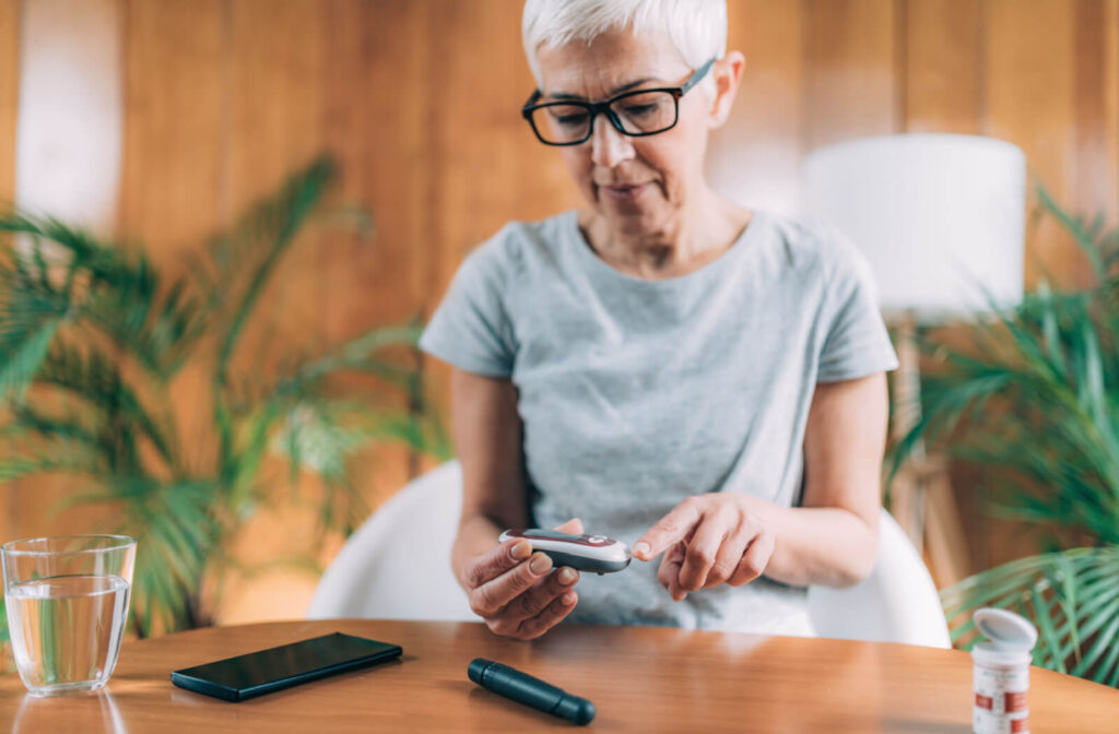 A person with diabetes checking their blood sugar levels to help manage their overall and eye health.